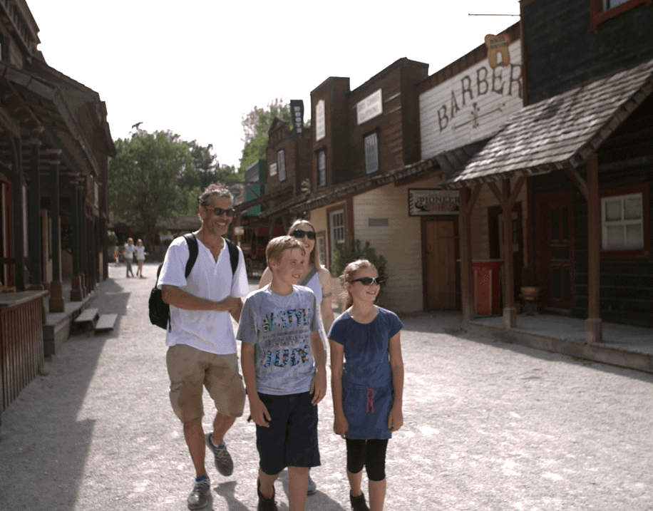 familie geht im erlebnispark durch eine westernstadt